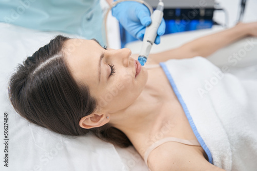 Woman receiving facial treatment in beauty clinic