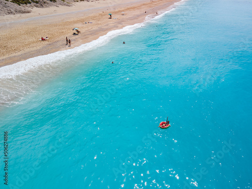 aerial view of greece beach woman floating on inflatable ring