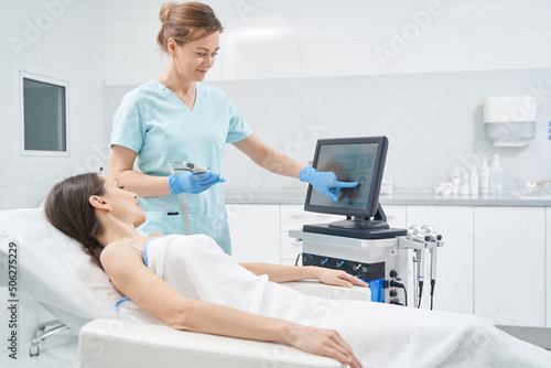 Beautician showing results of skincare treatment on monitor