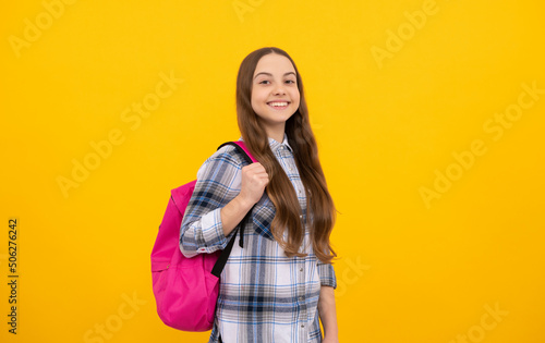happy kid in checkered shirt with school bag on yellow background, school © Olena