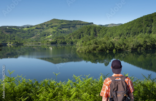 Hiker looking at the water and forest landscape between Navarra and Gipuzkoa.