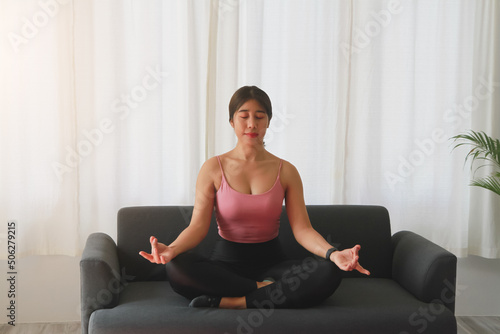 Woman practicing yoga at home from online classes after work. stress relief, muscle relaxation, breathing exercises, exercise, meditation.