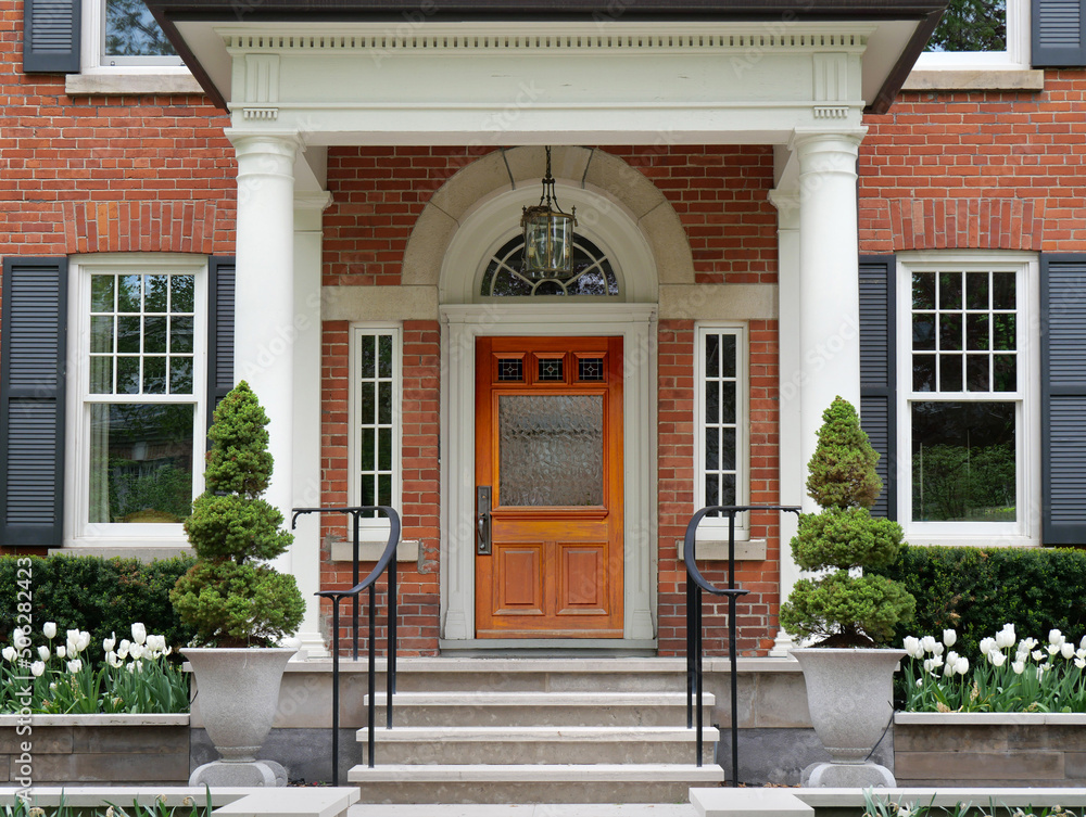 House with portico entrance and elegant wood grain front door House with portico entrance and elegant wood grain front door