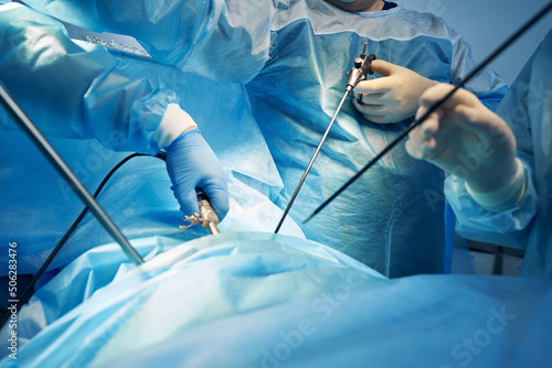 Surgeons working with laparoscopic instruments during operation photo