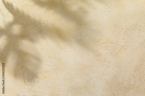 Soft light tree leaves shade on wall. Stone textured background with tropical pattern