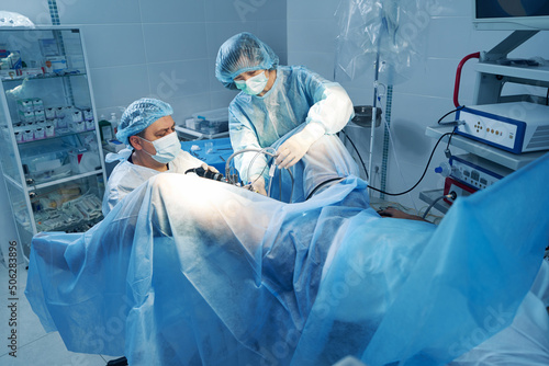 Nurse helping surgeon with laparoscopic camera control during operation