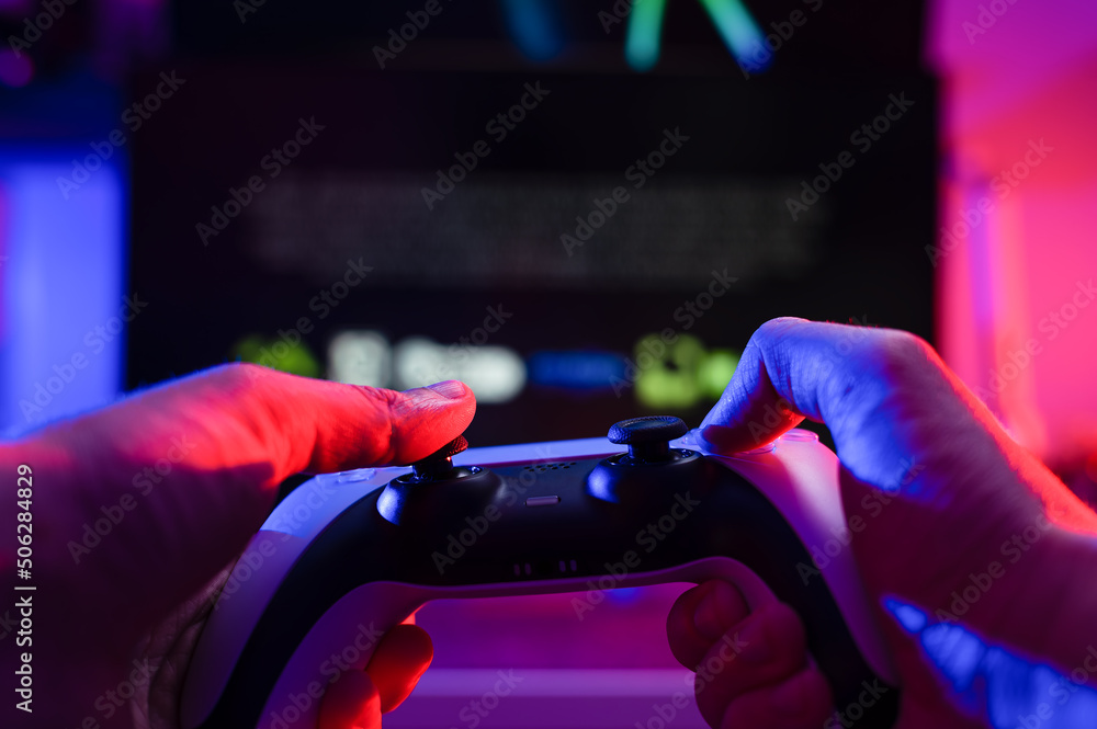Gamer plays video games with friends online. He has a modern gamepad in his  hands. Video games, entertainment, modern youth culture, cyberspace,  adventure games. Stock Photo | Adobe Stock