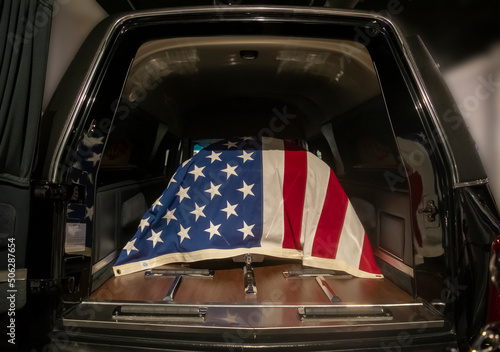 flag draped casket in hearse photo