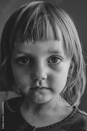 Dramatic black and white portrait of a little girl. Children's Day. The concept of family conflicts, child rearing, character problems, children's rights