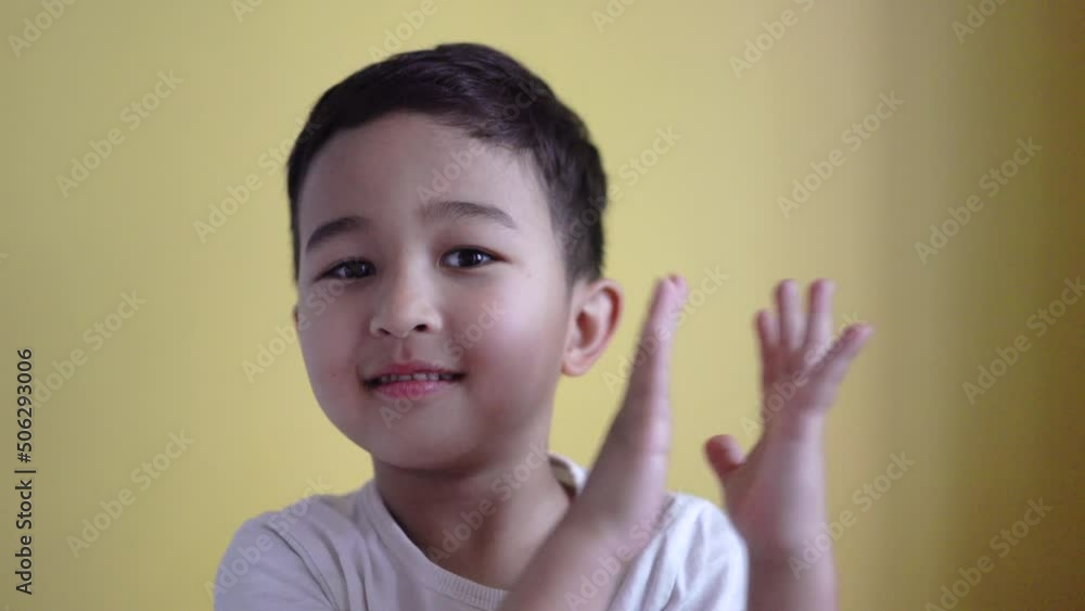 Cute boy clapping his hands on colour background Cute boy clapping his hands on colour background