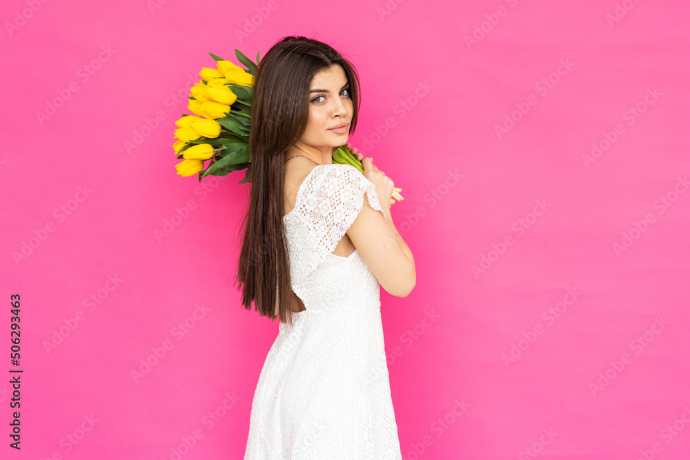 International Women's Day. Extremely happy woman is smelling a bunch of spring flowers, which she is holding in her hands. International Women's Day. Extremely happy woman is smelling a bunch of spring flowers, which she is holding in her hands.