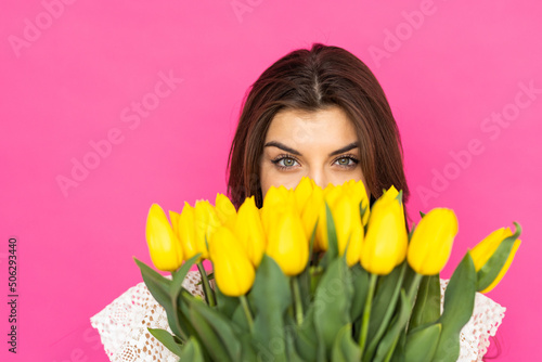 International Women's Day. Extremely happy woman is smelling a bunch of spring flowers, which she is holding in her hands.
