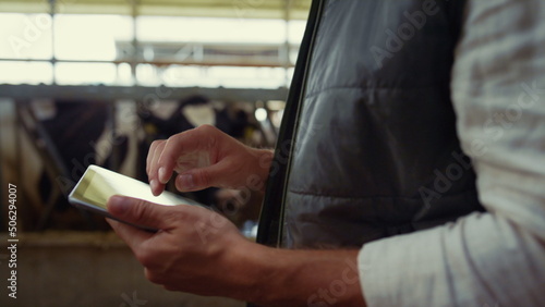 Farmer hands touching tablet screen closeup. Wireless technology at livestock. © stockbusters