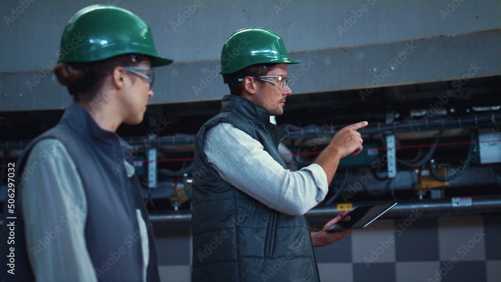 Fototapeta premium Agriculture supervisors inspecting manufacture facility together in uniform.