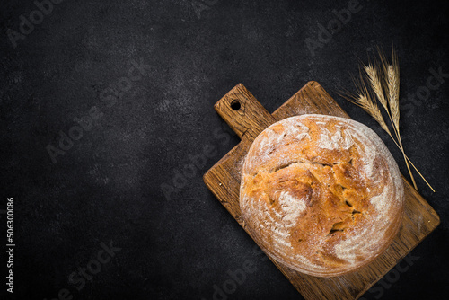 Fresh bread with whole grain flour at black table. photo