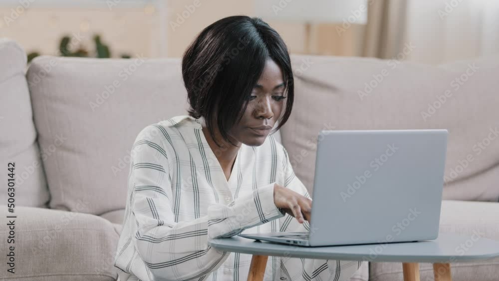 Focused young african american woman freelancer typing on laptop working remote at home girl distance learning using computer application makes order in online store browsing email on social network Focused young african american woman freelancer typing on laptop working remote at home girl distance learning using computer application makes order in online store browsing email on social network