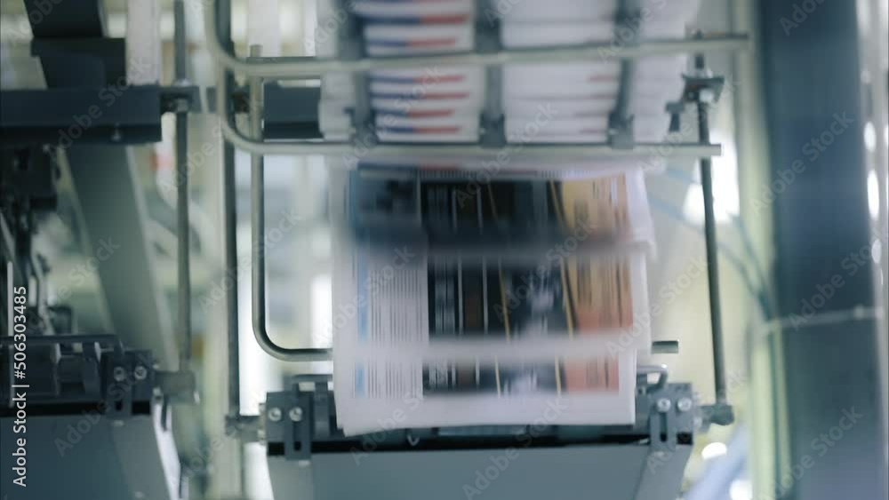 Newspaper production process before packaging and packing. Powerful industrial equipment of the printing house to quickly produce magazine. High quality FullHD footage Newspaper production process before packaging and packing. Powerful industrial equipment of the printing house to quickly produce magazine. High quality FullHD footage