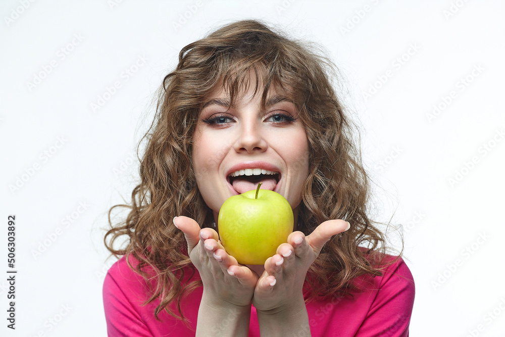 attractive girl is holding a ripe green apple in her hands. attractive girl is holding a ripe green apple in her hands.