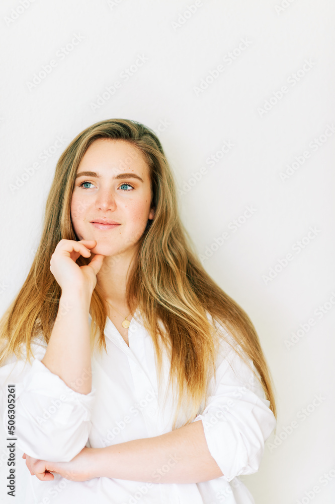 Indoor portrait of happy young female model, 20 year old girl wearing white shirt, healthy long blond hair Indoor portrait of happy young female model, 20 year old girl wearing white shirt, healthy long blond hair