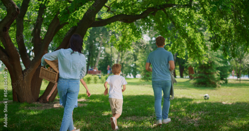 Walking family find place for picnic back view. Active leisure on nature concept Walking family find place for picnic back view. Active leisure on nature concept