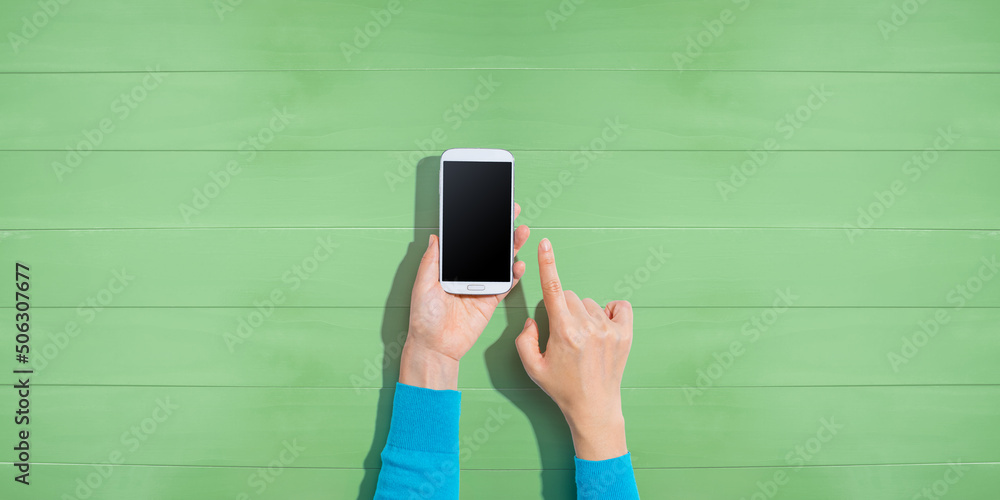 Person using a white smartphone - overhead view - obrazy, fototapety, plakaty 