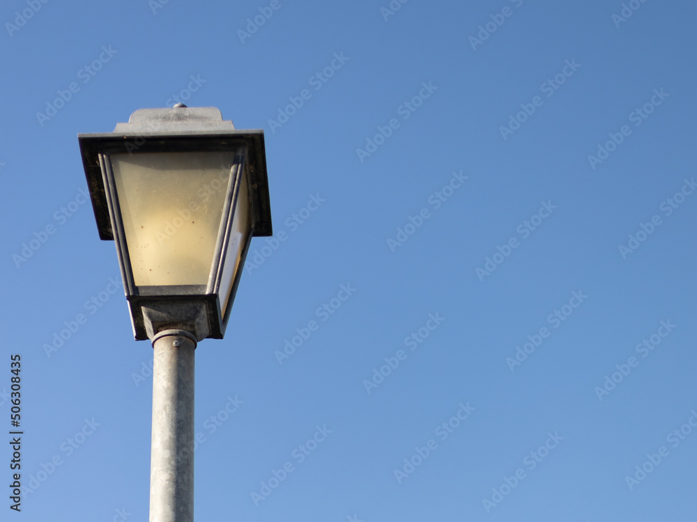 single streetlight during the day with blue sky background