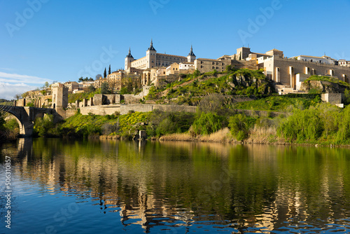 Scenic spring cityscape of old town of Toledo with Alcantara bridge and Alcazar fortress, central Spain