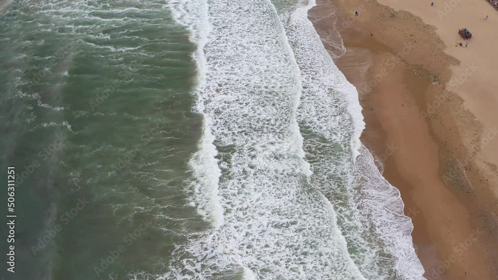 Aerial view of the sea and sandy beach in the summer season after a storm. Sea beach with ocean wave foam. Sea surface landscape with dirty water and algae. Summer holiday concept Aerial view of the sea and sandy beach in the summer season after a storm. Sea beach with ocean wave foam. Sea surface landscape with dirty water and algae. Summer holiday concept