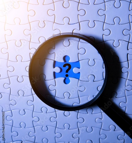 A magnifying glass and a question mark are placed in place of the puzzle pieces. Search concept.