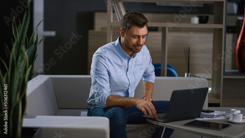 Excited entrepreneur leading videoconference using laptop in tech company office