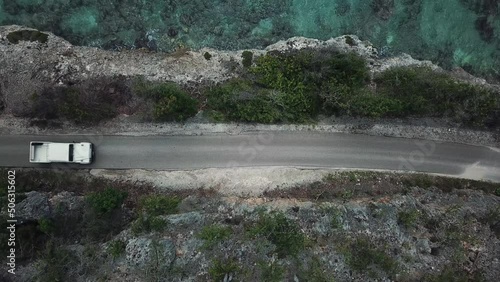 View from above of a white car traveling along the coast of Bonaire, in the Dutch Caribbean, in south america. photo