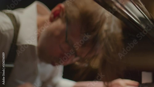 Close up handheld camera shot of virtuoso pianist playing intense piano music with emotion photo