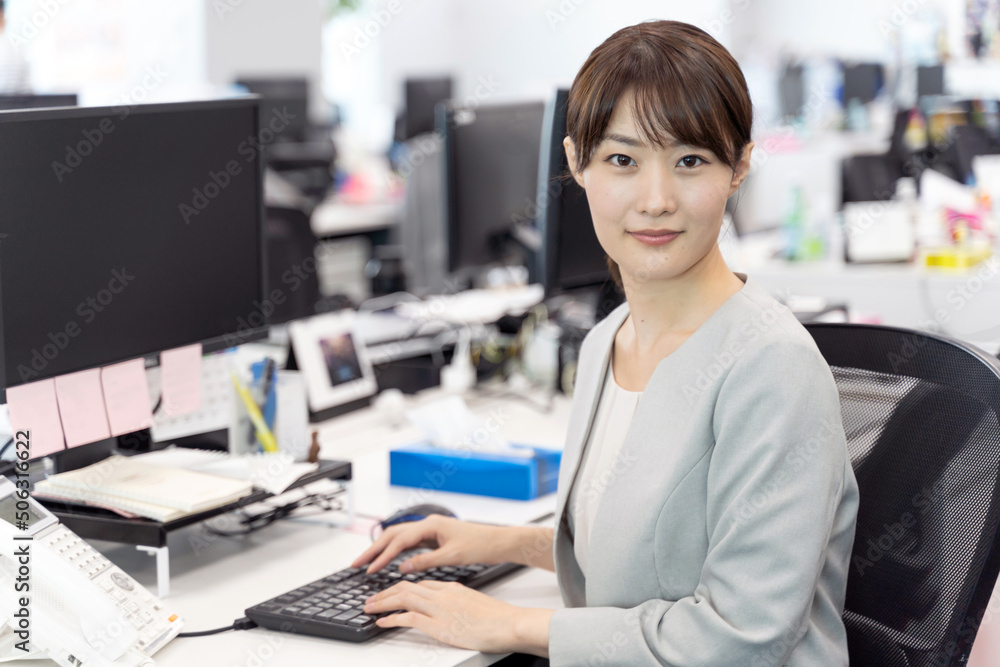 オフィスでデスクワークをするビジネスウーマン オフィスでデスクワークをするビジネスウーマン