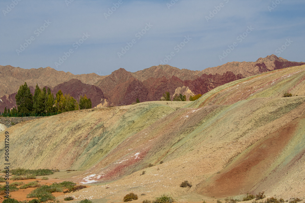 Dark red, yellow and green geological layers with blue sky and copy space for text, Zhangye Danxia Geological park, Gansu, China Dark red, yellow and green geological layers with blue sky and copy space for text, Zhangye Danxia Geological park, Gansu, China