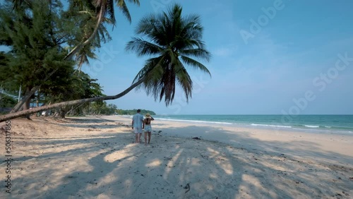 Couple on vacation in Thailand, Chumpon province, white tropical beach with palm trees, Wua Laen beach Chumphon area Thailand, palm tree hanging over the beach men and woman on the beach photo