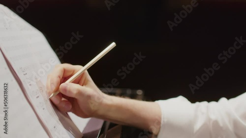 Close up view of talented composer creating sheet music and playing piano