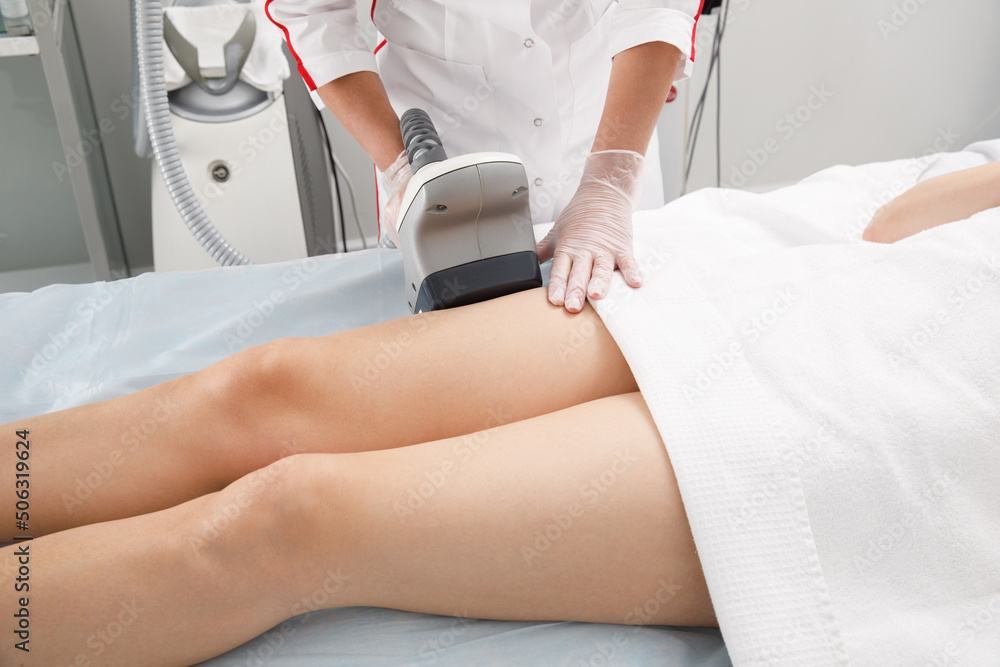 A woman undergoes an anti-cellulite procedure in a cosmetology clinic. A woman undergoes an anti-cellulite procedure in a cosmetology clinic.