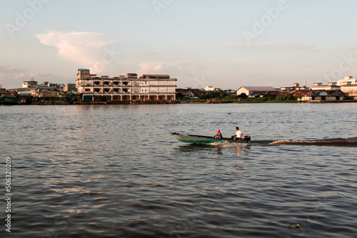Activities of local residents around the Kapuas river: fishing, cycling, and crossing the river using canoes.