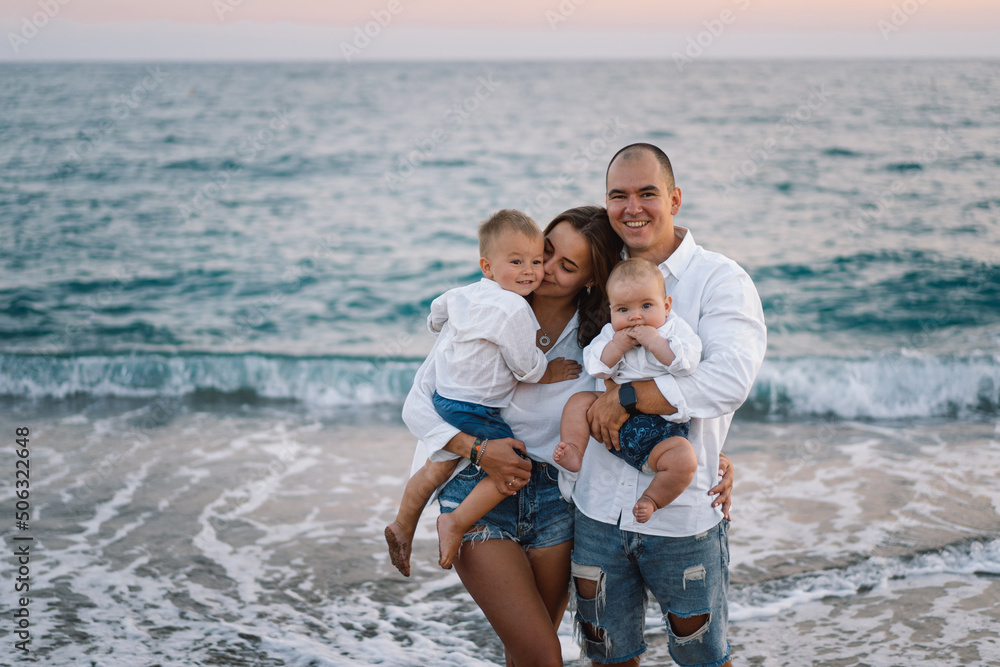 Happy family having fun playing beach in summer vacation on the beach. Happy family and vacations concept. Seascape at sunset with beautiful sky. Family on the beach. Happy family having fun playing beach in summer vacation on the beach. Happy family and vacations concept. Seascape at sunset with beautiful sky. Family on the beach.