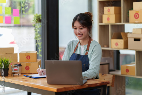 A portrait of Asian woman, e-commerce employee freelance with parcel box for deliver to customer. Online marketing packing box delivery concept.