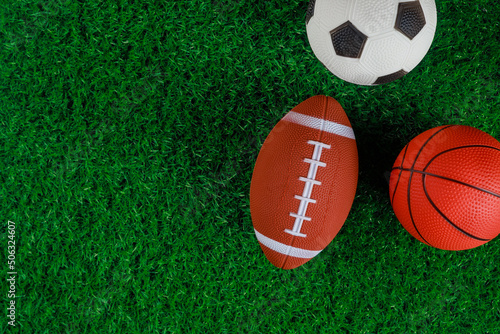 Close up of soccer  basketball and football balls on green grass background.