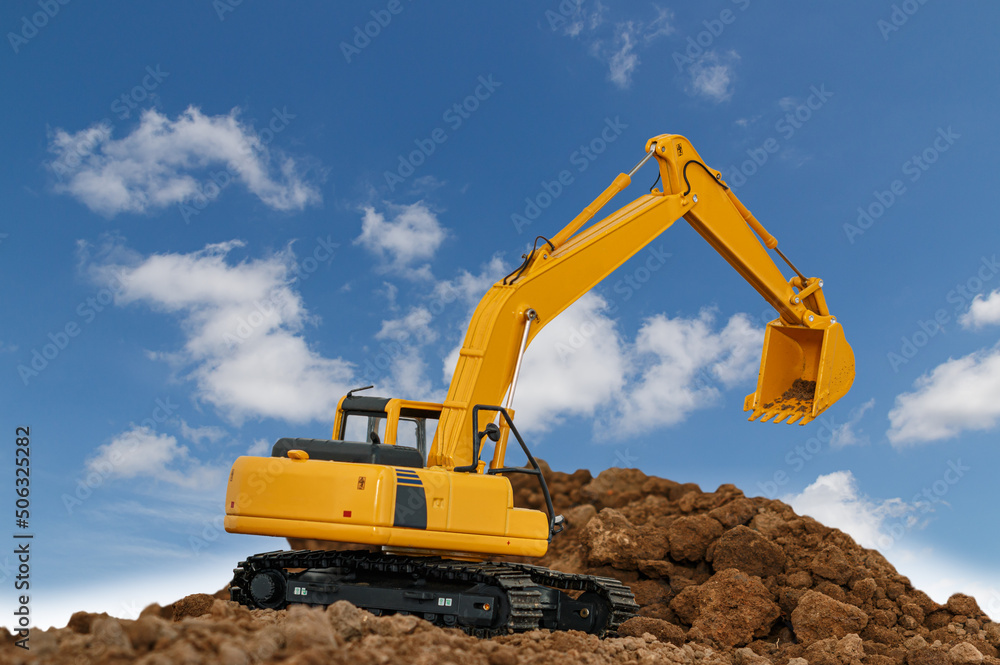 Excavator are digging soil in the construction site on sky background,with white fluffy cloud Excavator are digging soil in the construction site on sky background,with white fluffy cloud