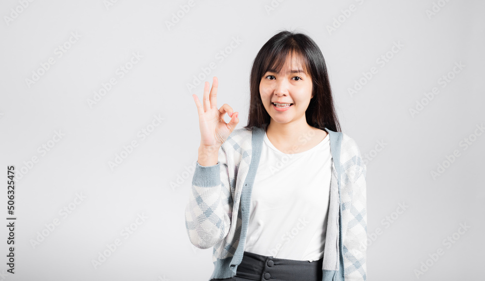 Woman smiling showing made finger OK symbol sign to agree studio shot isolated white background, Happy Asian portrait beautiful young female lifestyle agree hand sign with copy space Woman smiling showing made finger OK symbol sign to agree studio shot isolated white background, Happy Asian portrait beautiful young female lifestyle agree hand sign with copy space