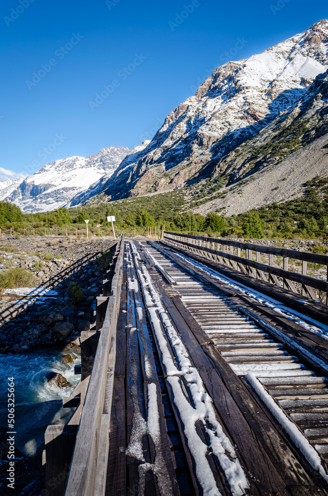 Winter landscape with a wooden bridge with snow