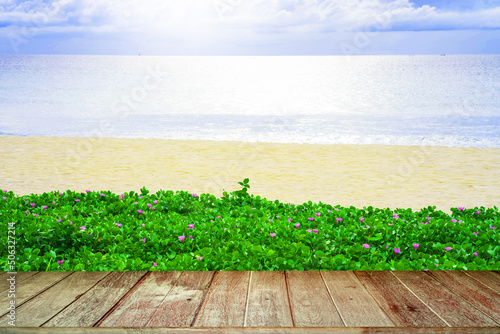 Old Wooden Textured Tabletop Against Growing Plant At Seashore Background.