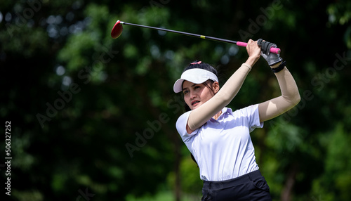 Professional woman golfer teeing to hole in player tournament competition at golf course for winner with green golf background.