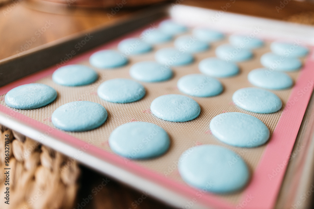 Bakery. Making macaroons. Blue macarons ready for baking lie on a tray on a wooden table. Biscuit Bakery. Making macaroons. Blue macarons ready for baking lie on a tray on a wooden table. Biscuit