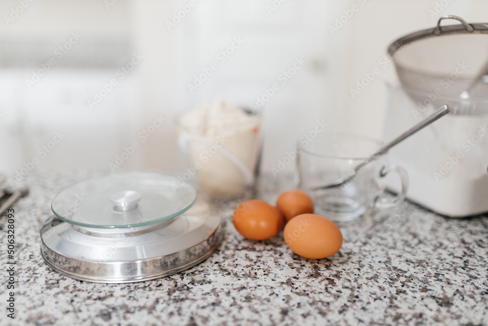 Baking ingredients are on the table. Eggs, flour, sugar are prepared for making macaroons. Kitchen background Baking ingredients are on the table. Eggs, flour, sugar are prepared for making macaroons. Kitchen background