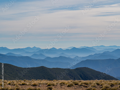 Sunset over mountain range silhouette from mountain top ridge line 