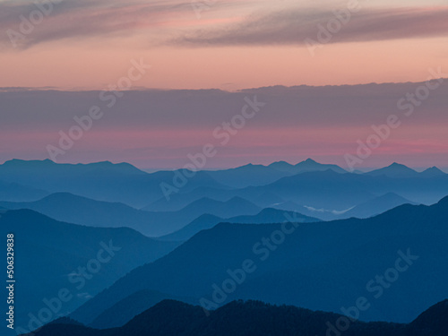 Sunrise over mountain ranges silhouette from mountain top sunset © Nicholas